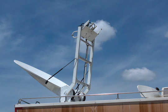 A boardcast white satellite mobile car with blue sky
