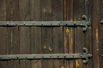 Wrought iron hinge with studs in an old wooden door