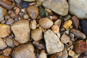 pebble or stone and rock ground on sand beach or river and stream with top view at travel trip for wallpaper or summer holiday background