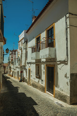 Old white houses with peeling plaster on deserted alley