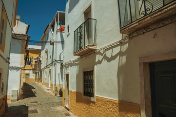 Old colorful houses with rough plaster wall in deserted alley