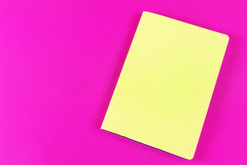 Bright lime notebook and on a bright pink background. Place for text. The concept of learning, sketch, writing. Flat lay, minimalism, top view, design.