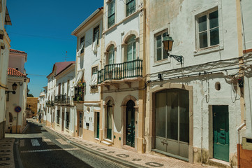 Fototapeta na wymiar Old houses with peeling plaster in a deserted street at Elvas