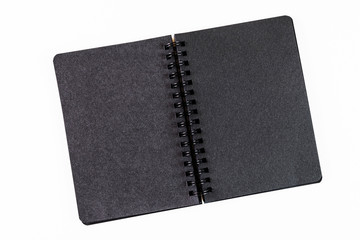 Open notebook with black pages on a spiral on a light background. Place for text. The concept of learning, sketch, writing. Flat lay, minimalism, top view, design.