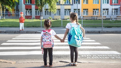 Back to school education concept with girl kids, elementary students, carrying backpacks going to class