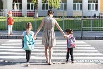 Back to school education concept with girl kids, elementary students, carrying backpacks going to class