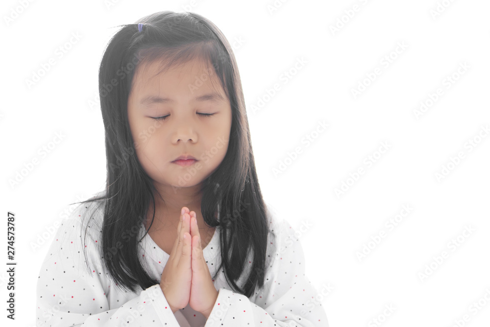 Wall mural Asian child cute hand in hand or kid girl pay obeisance and pray or raise close eye or sorry with wear white shirt in the morning at church or temple for peace on white space background isolated