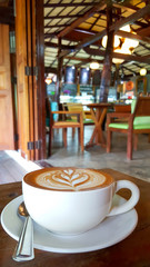 Hot cappuccino coffee in the cup on wood table. Cappuccino mixed with espresso coffee, milk is a fine foam and milk pressurized steam. Sometime garnished with cinnamon powder or cocoa powder on coffee