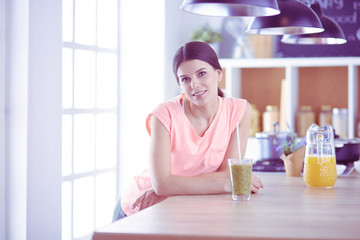 Young woman sitting a table in the kitchen