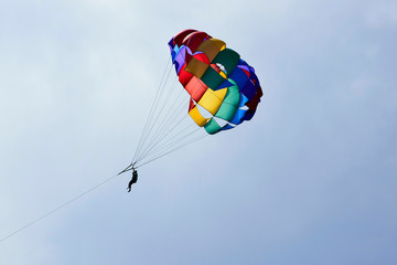 Vacation, extreme sports - colorful parachute over the sky with clouds.