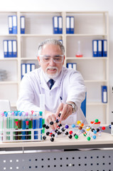 Old male chemist working in the lab 