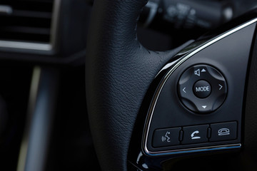 close up Modern black steering wheel with multifunction buttons Integrated stereo controls pushes the for quick control technology in the car. 