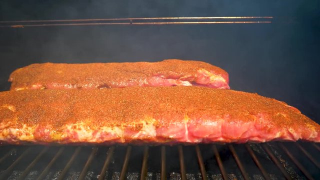 Using a smoker to cook ribs - close up sliding view