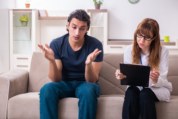 Young male patient discussing with female psychologist personal 