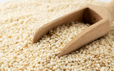 Sesame seeds with wooden spoonc lose up.