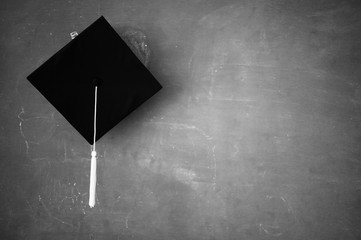 Black graduates hat hung on the blackboard