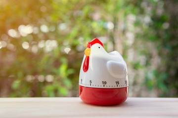 Cooking timer as chicken on the wooden table
