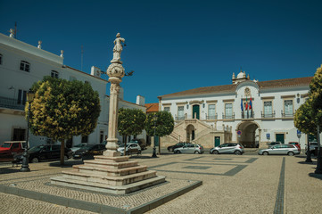 Obraz premium Marble pillory with sculpture in square and City Hall in the back