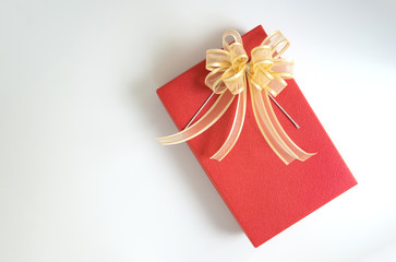 Flat lay of minimal red gift box with ribbon on the white isolated background