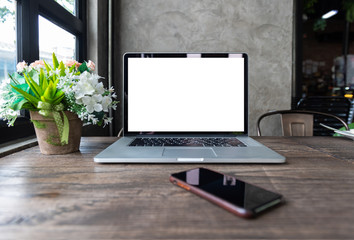Fototapeta premium Blank screen of laptop computer with smart phone on wooden table