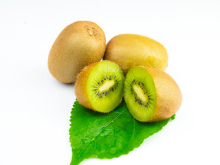 Green kiwi fruit and halves on leaves, isolated on a white background.