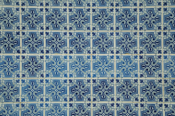 Blue floral pattern on ceramic tiles in an old house facade