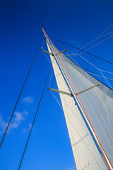 Main sail of a sailing yacht against a blue sky