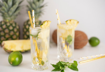 Cold pineapple cocktail with crushed ice, lime, coconut and mint, tropical refreshing lemonade drink