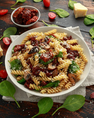 Fusilli Pasta with sun dried tomatoes, mushrooms, parmesan cheese and spinach. healthy food.