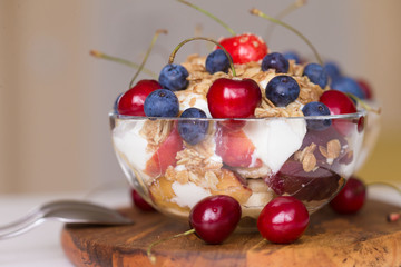 Food. Fruit salad with cherries, blueberry, muesli, yogurt