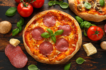Homemade Pepperoni, Salami, mushroom Pizza with basil, tomatoes, cheese on wooden table. ready to eat