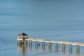 Unknown people fishing at gazebo at sea coast