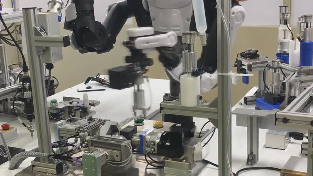 Android robot works in a high-tech production workshop.