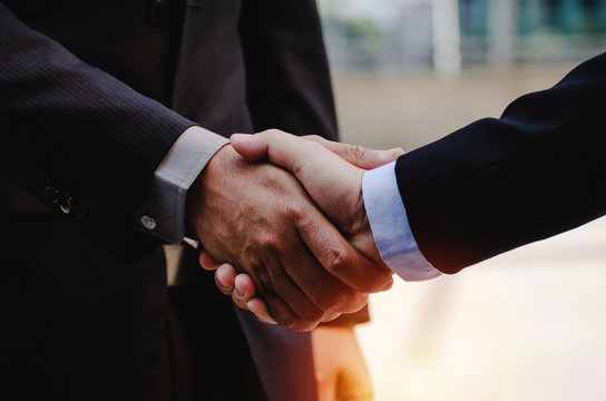 close up of business man in suit shaking hands after finishing up a business meeting in city with during sunrise, congratulation, success, meeting, partner, teamwork, partnership, connection concept