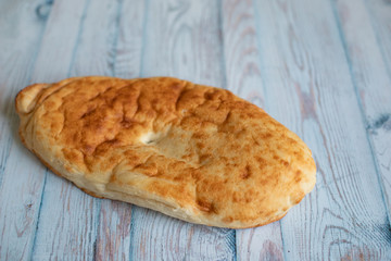 Traditional Georgian lavash bread on blue background with space for text