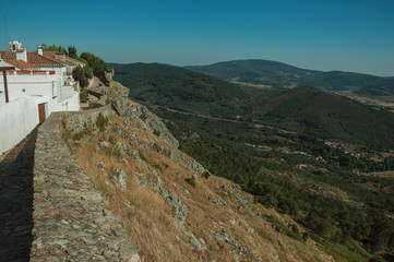 Old houses and stone breastwork with mountainous landscape