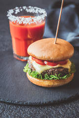 Hamburger with a glass of tomato juice
