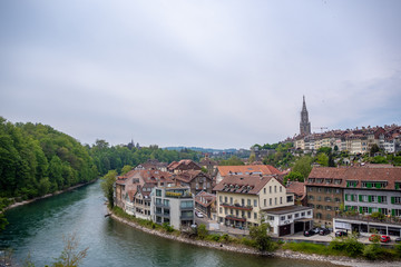 Fototapeta na wymiar Beautiful panorama view of aare river and downtown in bern on cloudy sky background