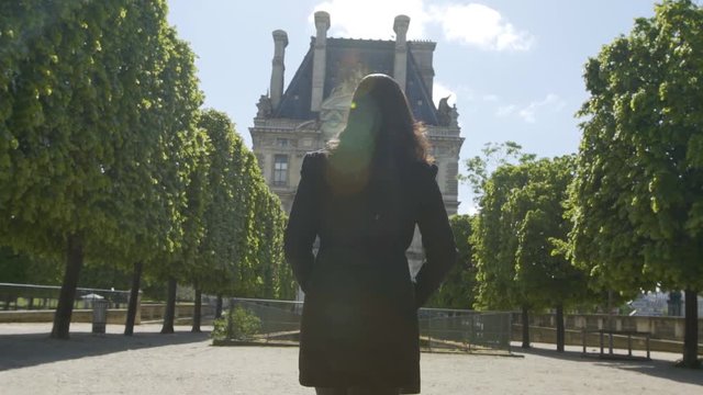 girl walking in slow motion in Tuileries Gargen Paris France on a sunny day