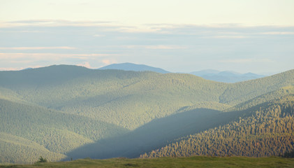 Fototapeta premium green mountain chain at the evening in the light haze