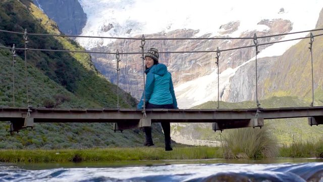 girl sit on a bridge on the Cordillera Huayhuash Peru mountain watching nature