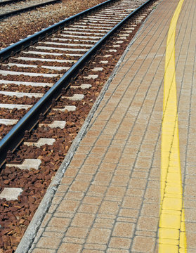 Railway Tracks And Platform With Yellow Line