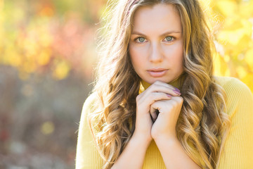 Naklejka premium Young attractive blond woman outdoors on fall background. Autumn portrait of beautiful stylish woman.