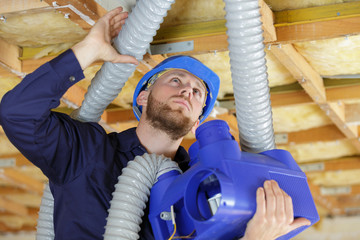 builders working on house ventilation pipes