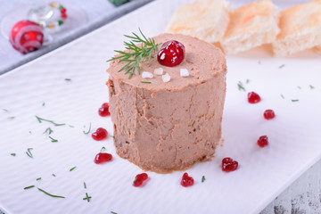 Foie gras garnished with berry sauce and sea salt on the white plate