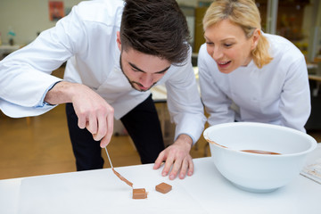 trainee confectioner preparing chocolate squares