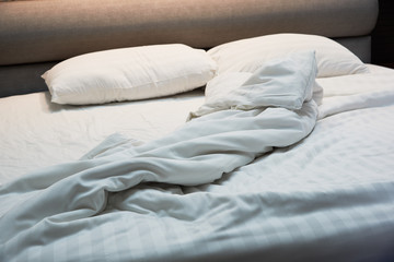 Fototapeta na wymiar Untidy blanket, pillows on the bed