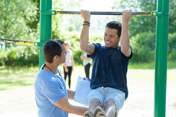 young man in training on monkey bars lifting his legs - Powered by Adobe