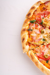 Half pizza on white wooden background copy space top view 