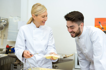 Obraz premium man and woman chefs cooking food at restaurants kitchen